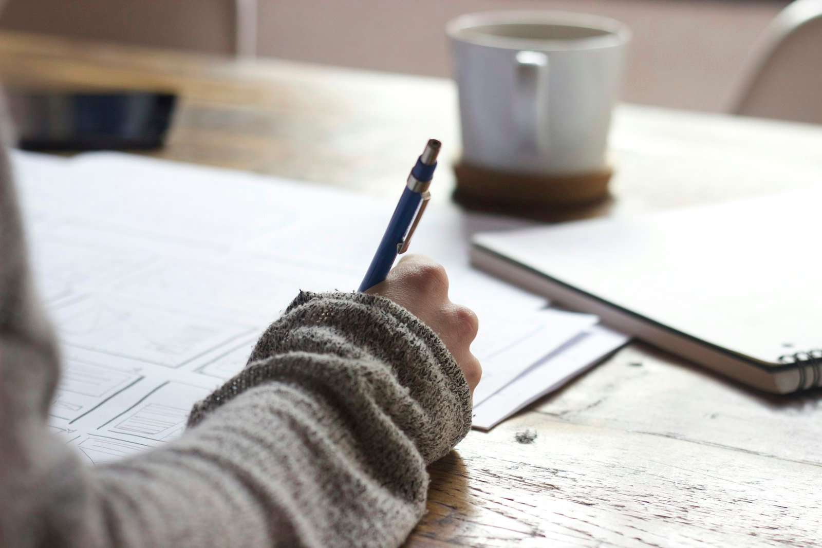 Adult learner taking organized handwritten notes at a bright desk